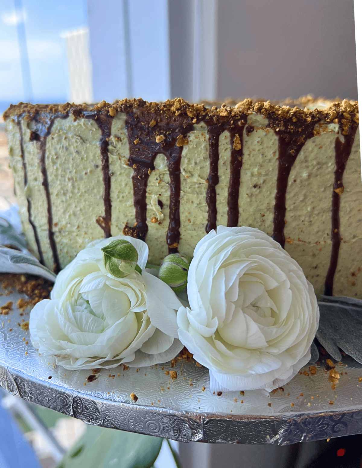 close up for gluten free vegan cake with green buttercream and flowers