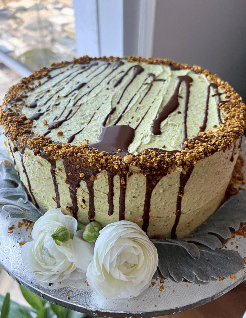 close up for gluten free vegan cake with green buttercream and flowers