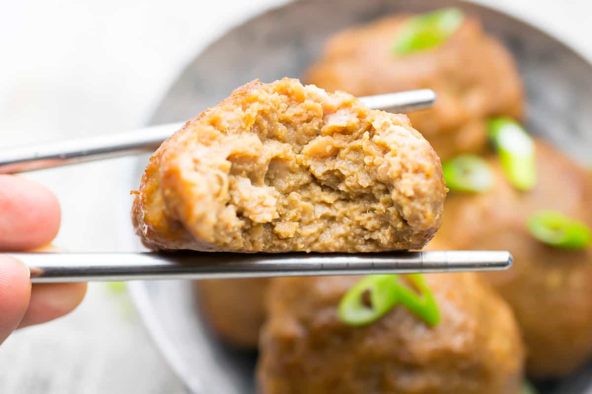 aip turkey meatballs being held between chop sticks with bite taken out of it 