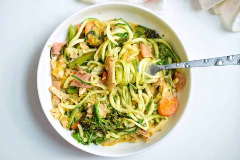 white bowl on white background with vegetables and chicken