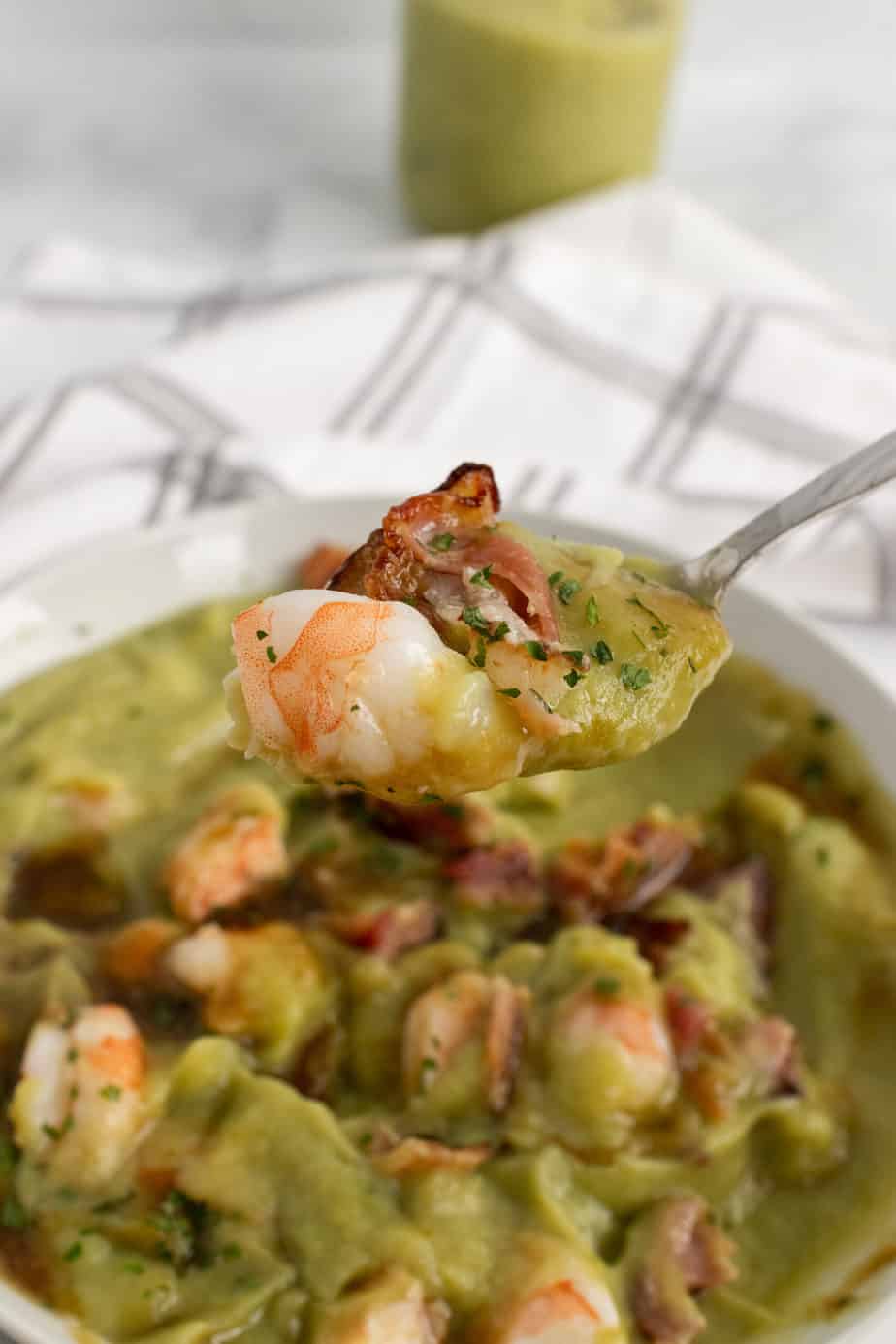 close up of a bite of aip breakfast bowl- shrimp chunks and bacon bits over veggie puree garnished with cilantro