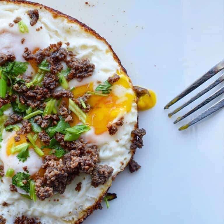 fried eggs topped with roasted lemon crispy beef and green onion