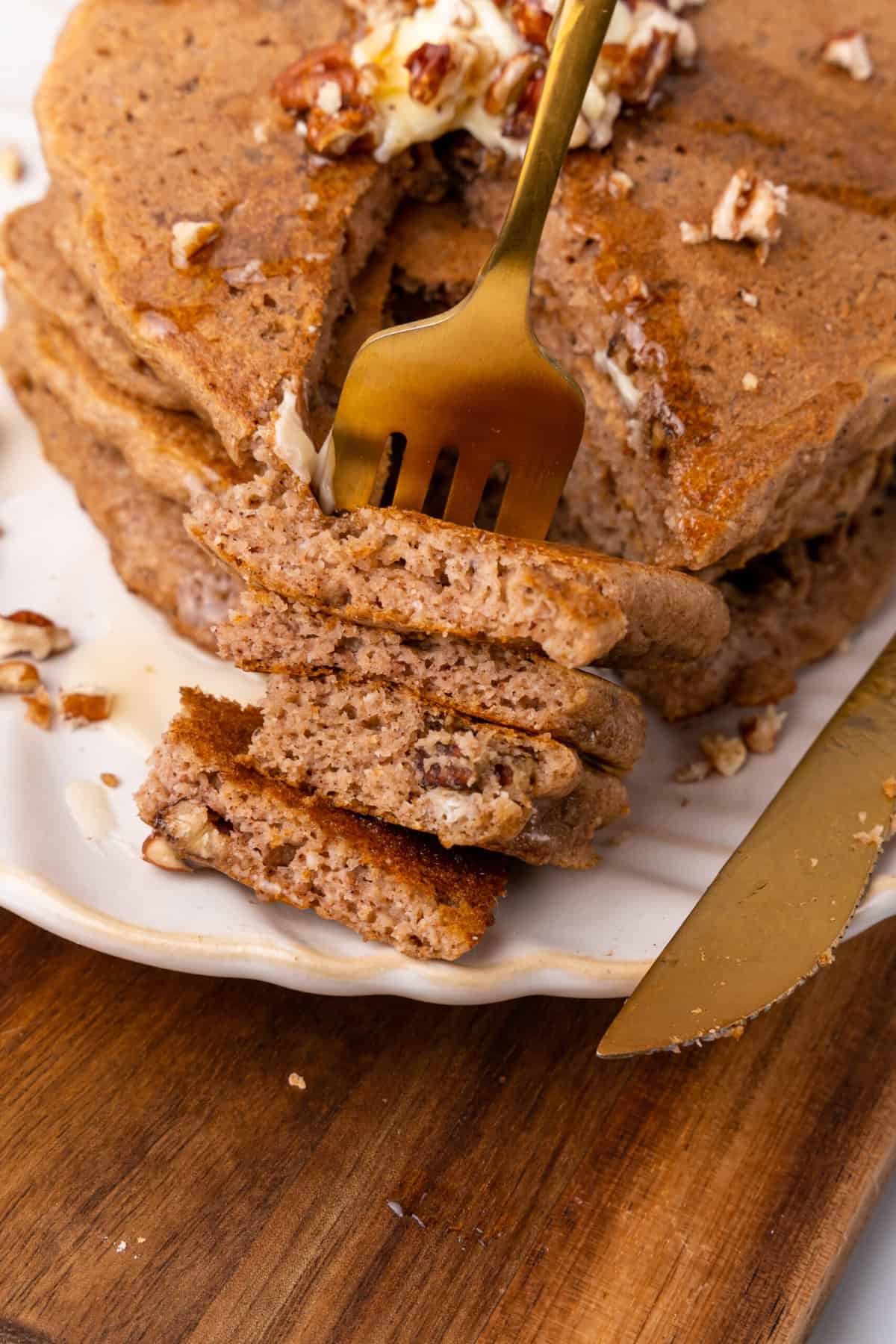 taking a bite of stacked pumpkin spice paleo pancakes