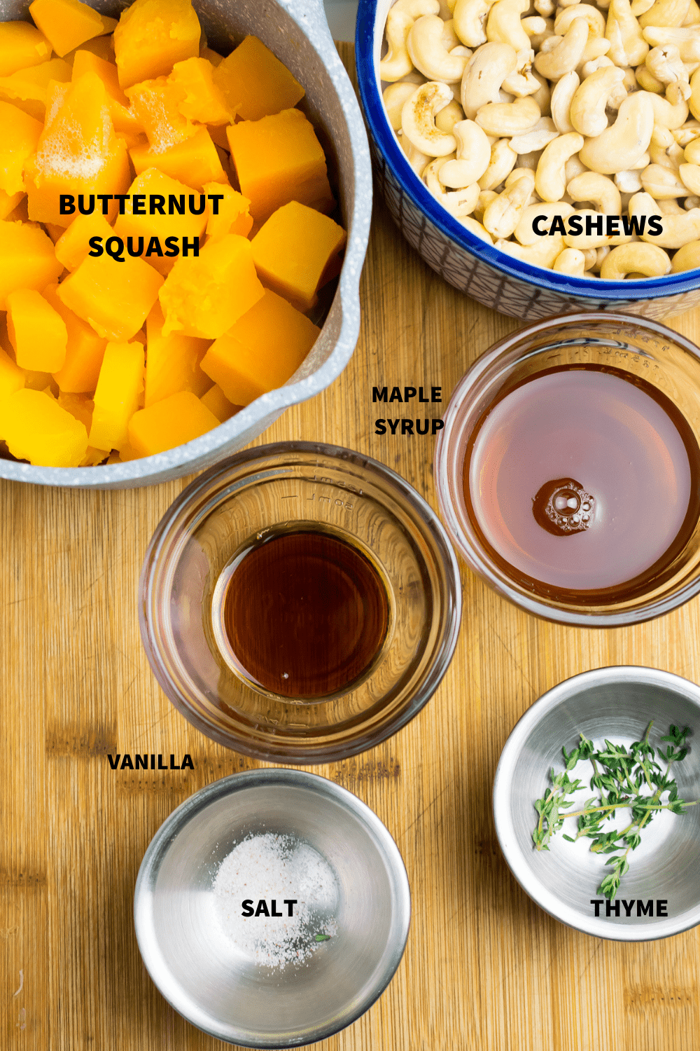 Ingredients for vegan butternut custard on a cutting. board including cashews, vanilla, maple syrup and vanilla