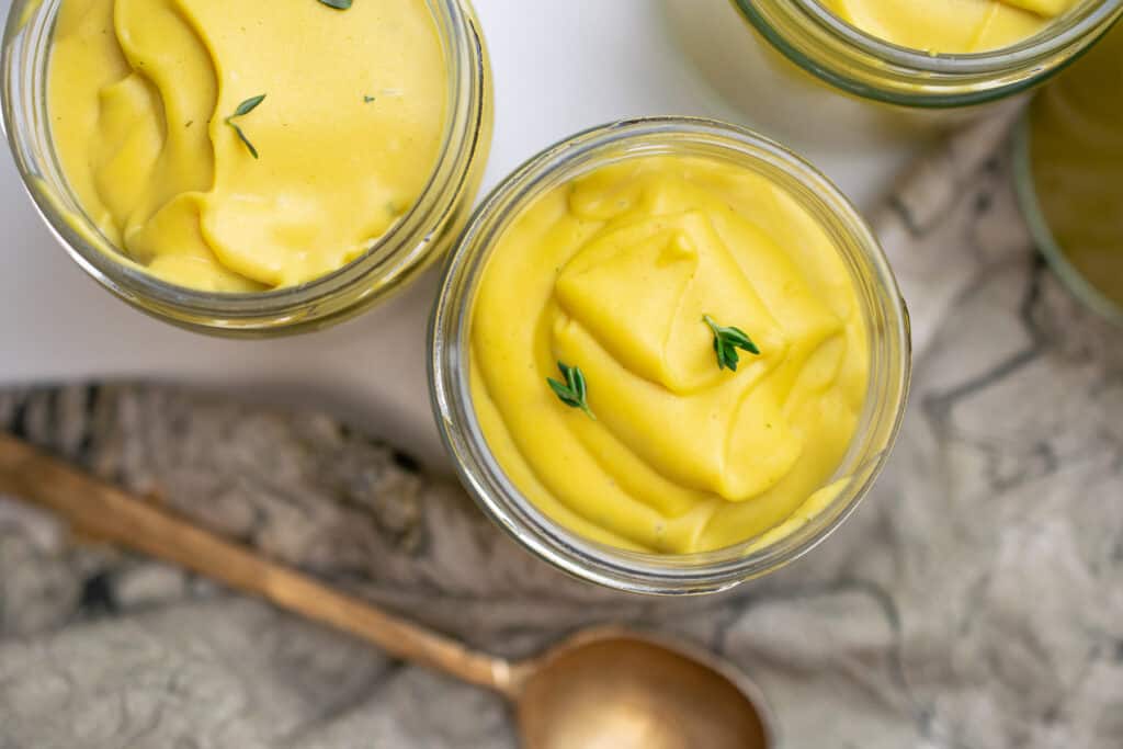 paleo custard egg free in jars on a counter with napkins and a golden spoon