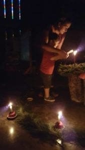 children lighting advent candles in the dark