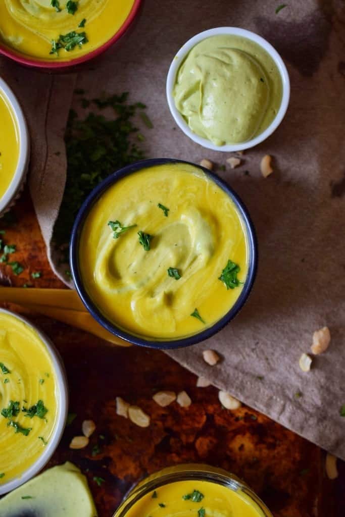 small bowls of roasted butternut squash soup with avocado crema