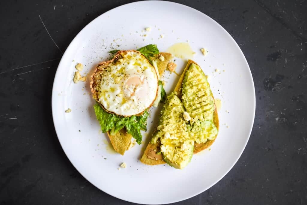 black background with avocado toast and egg 