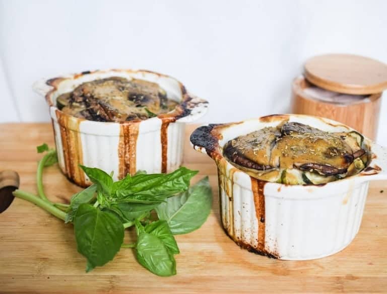 cooked mini lasagna bianca on wooden cutting board with basil