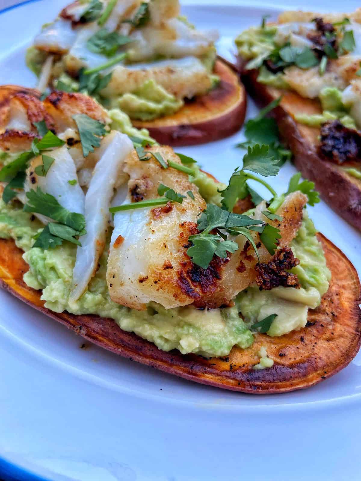 sliced sweet potato loaded with avocado, grilled fish and cilantro