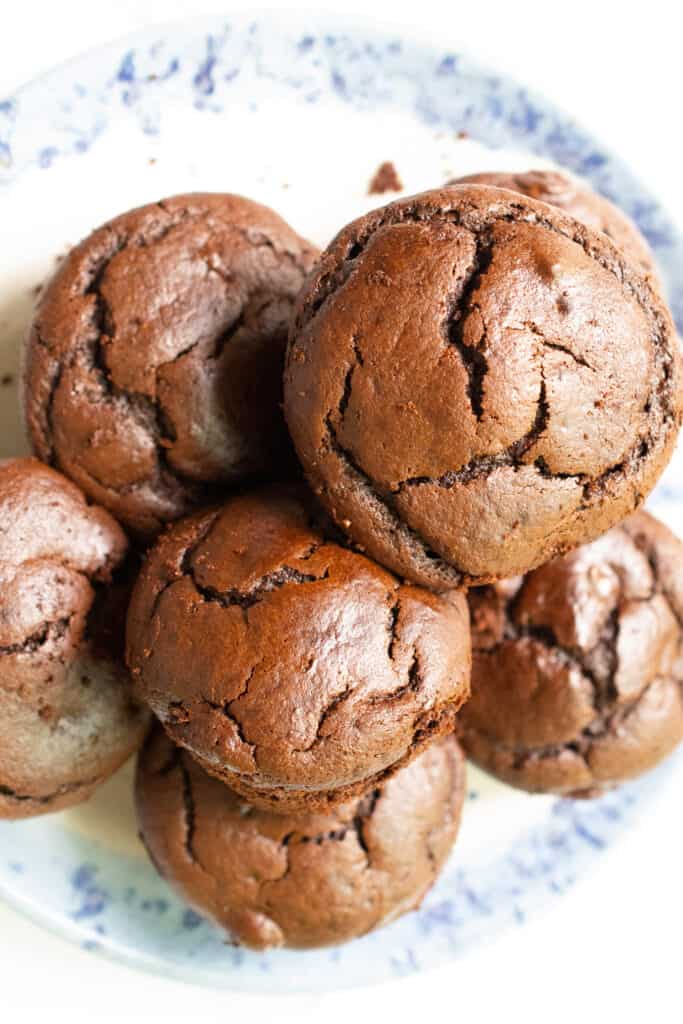 flourless chocolate muffins gluten free piled on blue plate with white counter