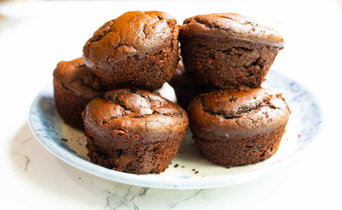 flourless chocolate muffins gluten free piled on blue plate with white counter