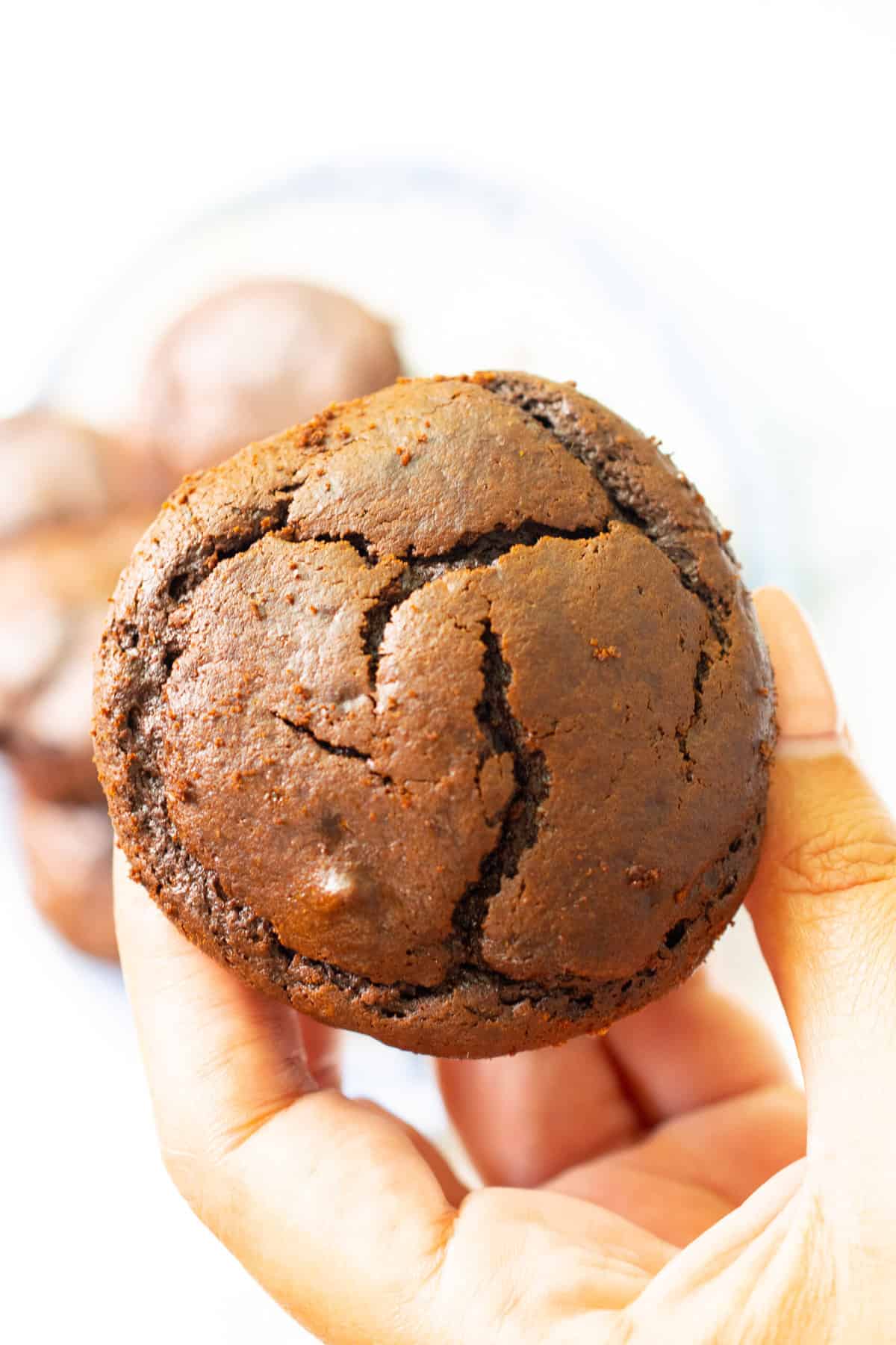 hand holding a flourless chocolate muffin