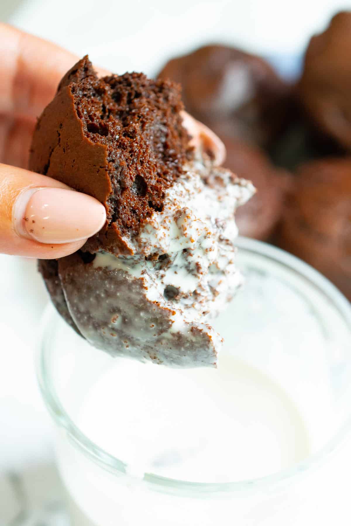 flourless chocolate muffins thats been bitten into being dipped in milk