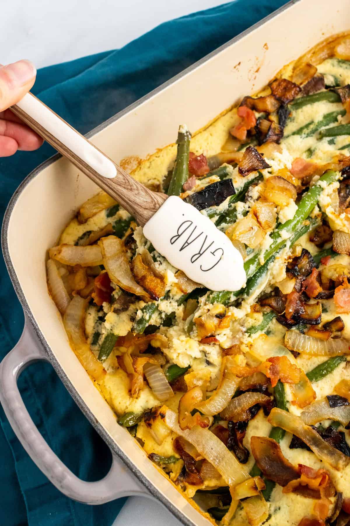 paleo green bean casserole being served with tongs that say grab