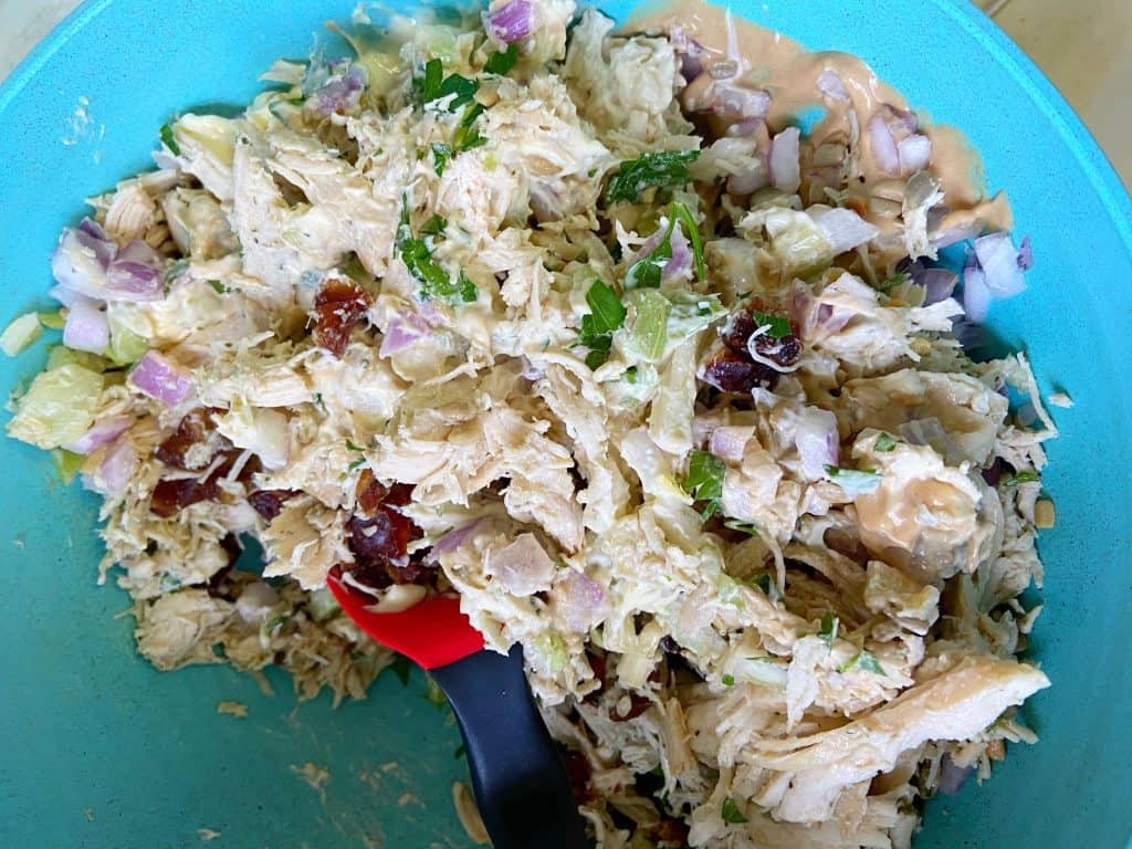 A large teal bowl with shredded chicken salad.