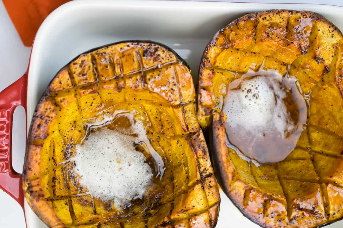 brown butter acorn squash cut with pools of melted butter 