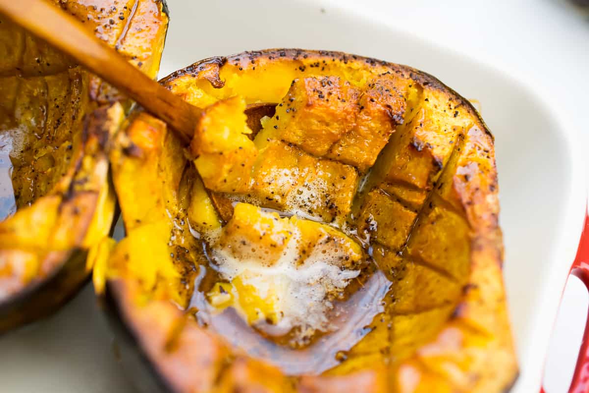 close up of roasted acorn squash with pools of brown butter 