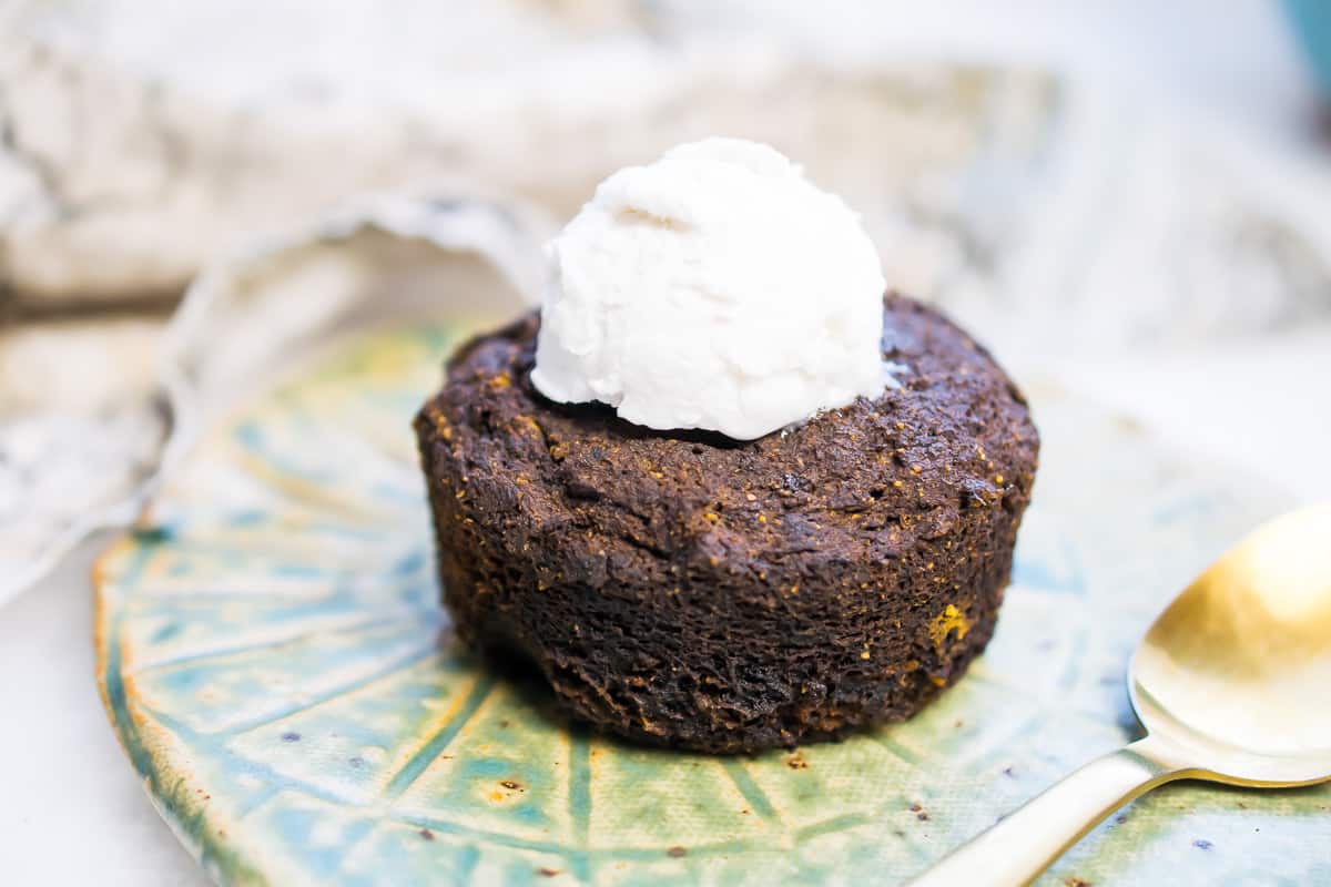 chocolate aip cake with coconut cream scoop on top and gold spoon on the side