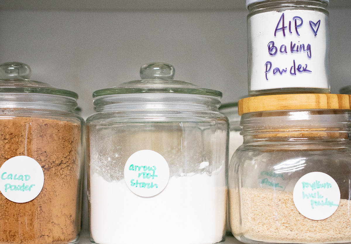 small jar of aip baking powder  on top of jar of psyllium husk powder, next to a jar of arrowroot starch and jar of cacao powder