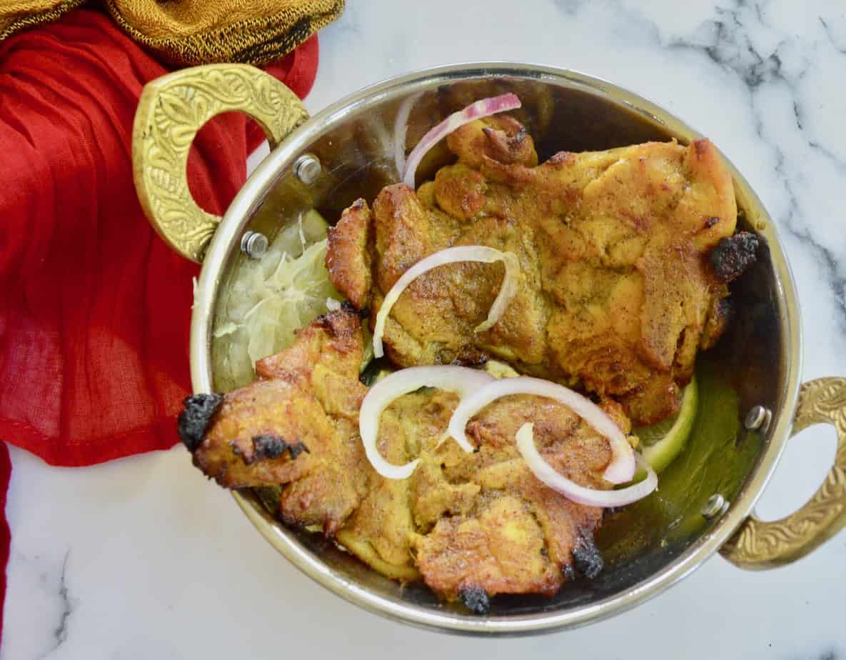 aip tandoori chicken in serving dish - over lemon with onion garnish 