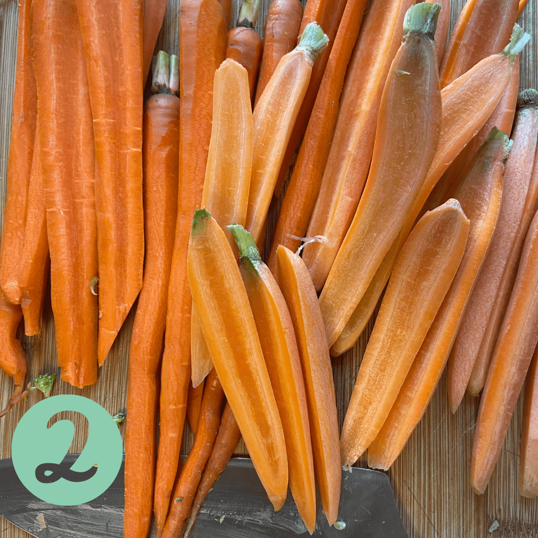 a bunch of halved carrots on a cutting board