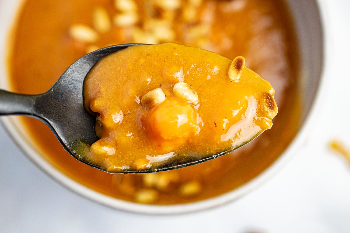 spoonful of sweet potato porridge close up with pine nuts  