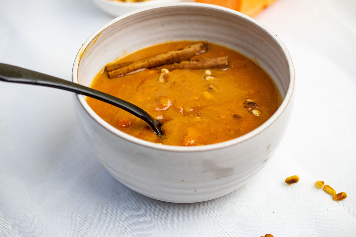 sweet potato porridge in a bowl with toasted pine nuts