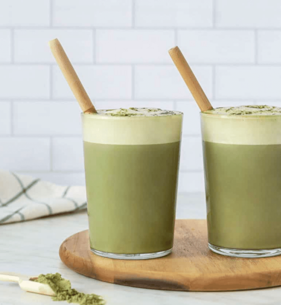 two cups with creamy aip iced matcha and straws on a cutting board