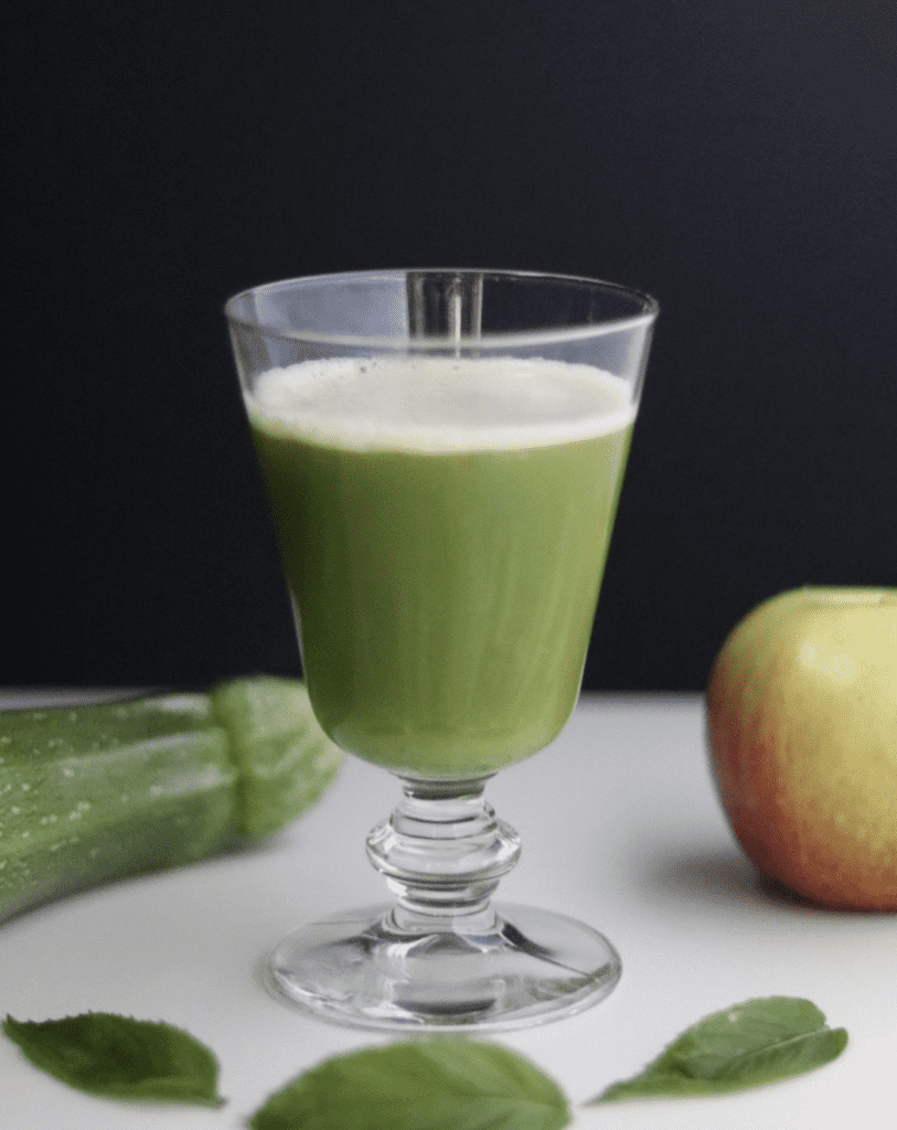 a wine glass full of green apple juice