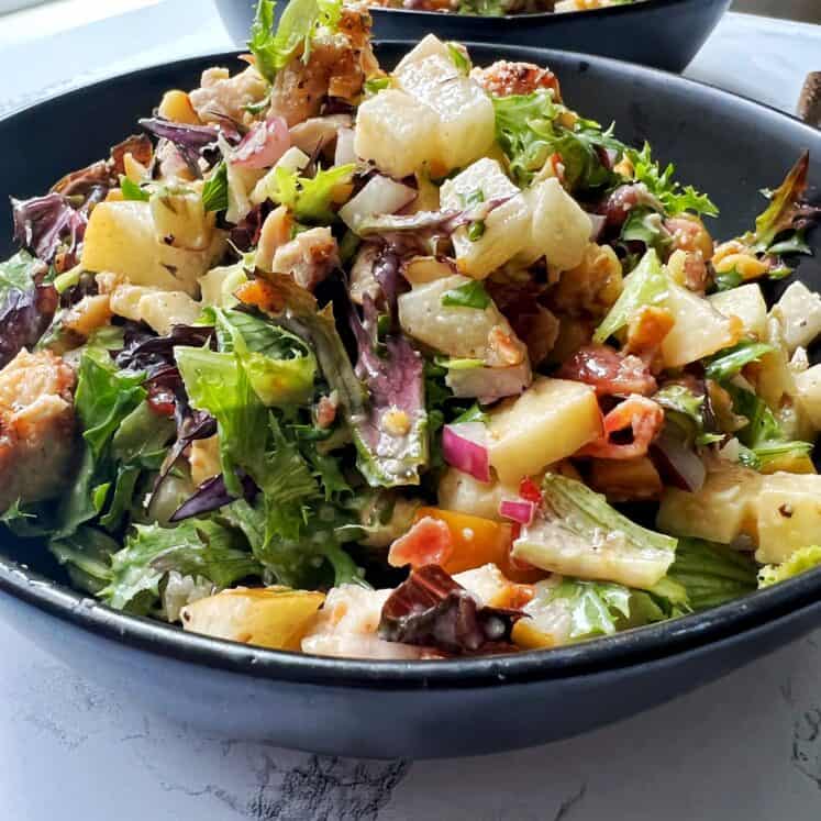chopped chicken and apple salad in a black bowl