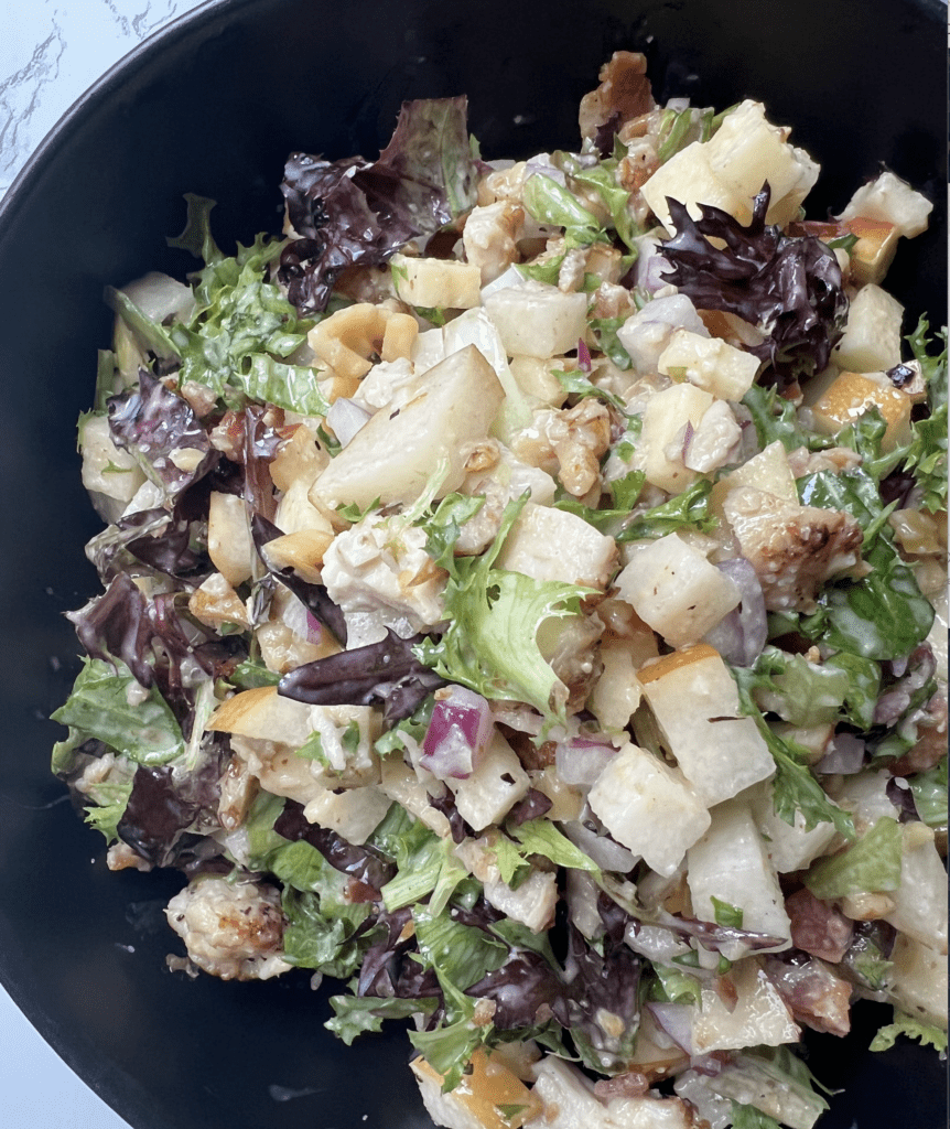 chopped chicken and apple salad in a black bowl