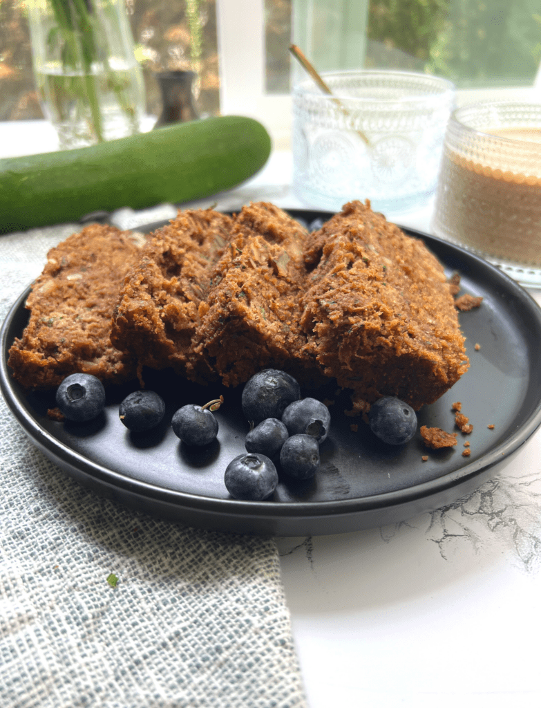 paleo zucchini bread on a black plate with blueberries