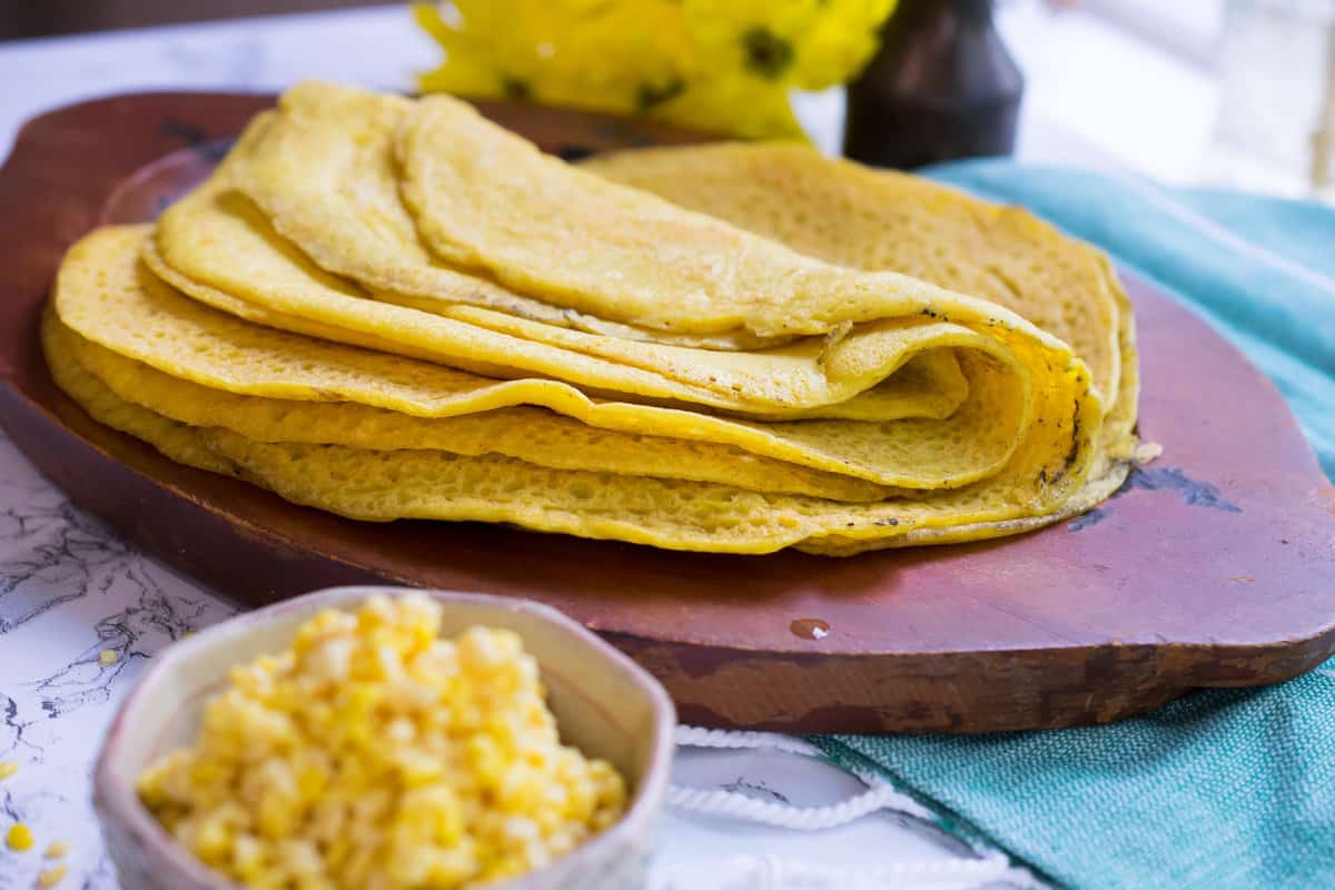 stack of yellow lentil wraps on a wooden tray