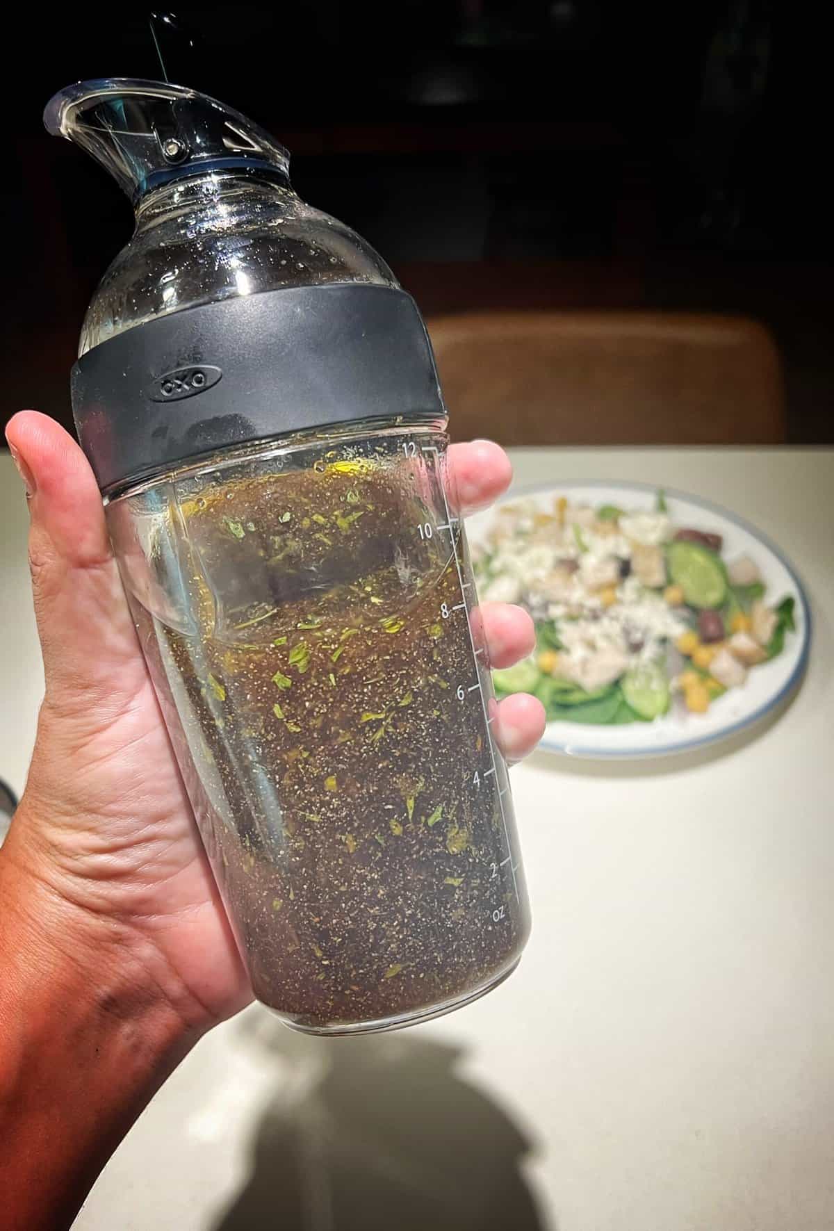 dressing bottle with greek salad dressing over a kitchen counter