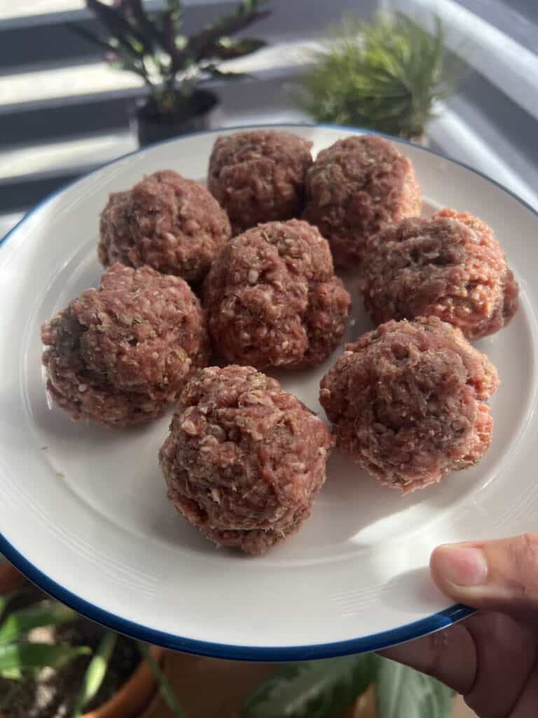raw lamb meatballs on white place